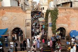 Image du Maroc Professionnelle de  Médina de Casablanca quelque soit l'angle choisi , des amas de caisses, d'objets ou de poubelles empestent ce lieu malgré qu'il fait partie du patrimoine historique de la Médina de Casablanca. El Bab E Jdid subit une dégradation due au vieillissement et à l’absence d’entretien, mais surtout au voisinage qui ne respect rien pour se protéger du soleil une bâche a été accroché à gauche avec du ciment sur la muraille de la ville au Boulevard Tahar El Aloui, ex (2e Tirailleurs). Par ailleurs les deux petites portes réservées aux passage des piétons sont devenue la propriété des cafés qui se situent de chaque côté de la porte dont on aperçoit quelques chaises, Vendredi 10 juillet 2009. (Photo / Abdeljalil Bounhar)